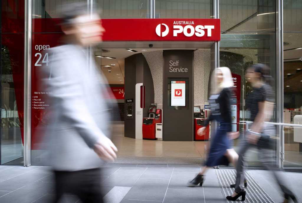 Image of blurred people walking in front of an Australian Post office